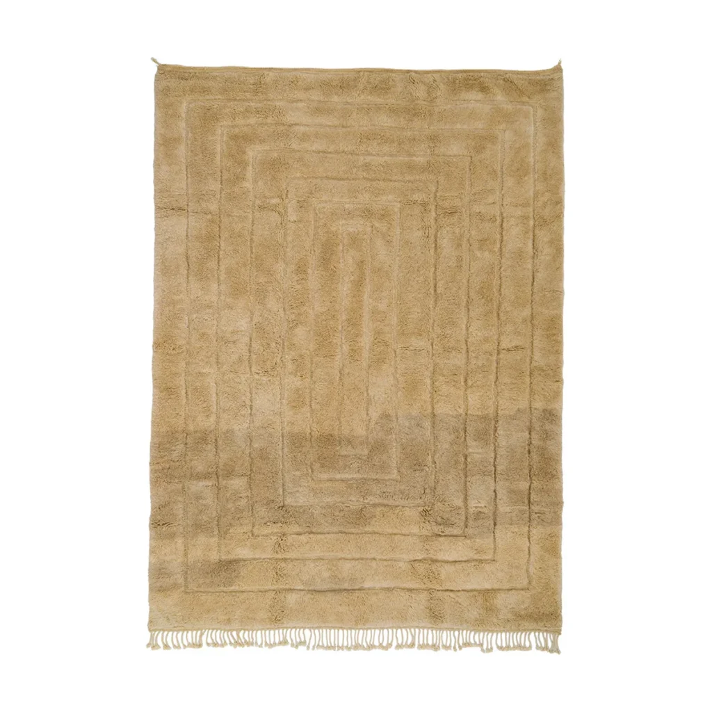 This hand-knotted beige rectangular rug boasts a textured pattern and fringe on the shorter sides, offering a touch of Moroccan luxury to any room.