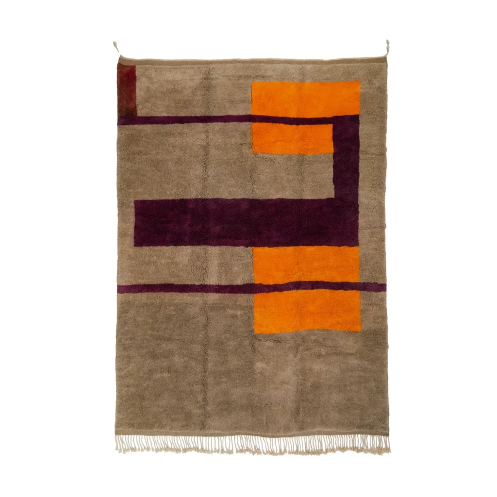 This luxury, hand-knotted rectangular rug showcases a geometric design with vibrant orange and purple shapes against a beige backdrop. The fringed edges at the bottom add a touch of elegance and sophistication to any room.