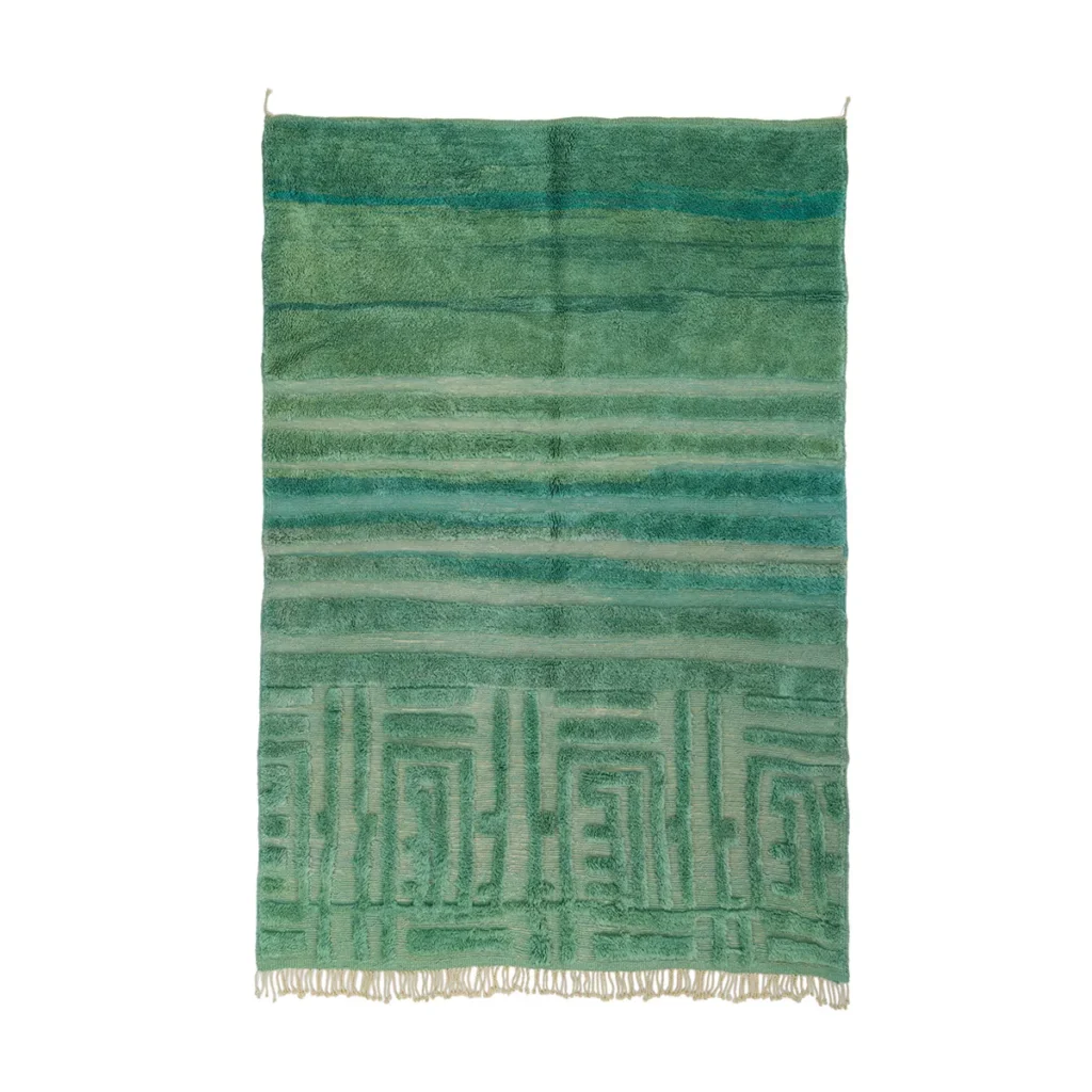 This luxurious green woven rug features horizontal stripes and fringe. The top showcases varying dark green shades, while the bottom reveals lighter stripes with a geometric pattern. Expertly hand-knotted, it adds an elegant touch to any room.