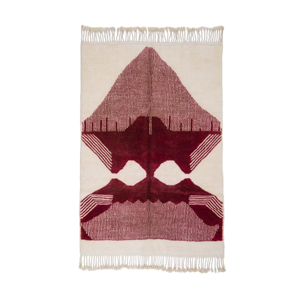 This luxurious hand-knotted rectangular rug boasts fringed edges and showcases a geometric pattern in burgundy and cream, reminiscent of abstract symmetrical shapes.