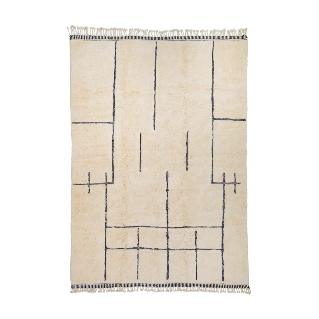 A hand-knotted, cream rectangular rug featuring a minimalist geometric black line pattern and fringe on the shorter edges. This luxury rug adds an elegant touch to any space, blending timeless style with exquisite craftsmanship.
