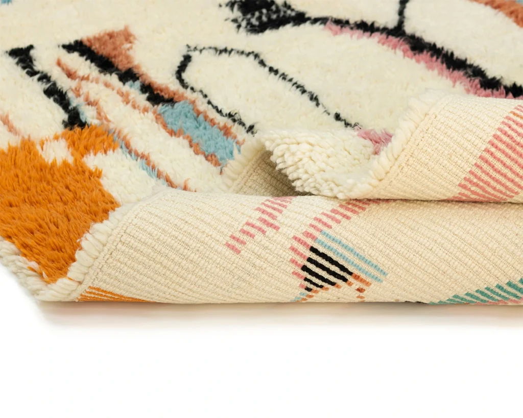 Close-up of a rolled, hand-knotted tapestry rug showcasing its intricate patterns on the surface and underside, embodying the essence of authentic Moroccan rugs.