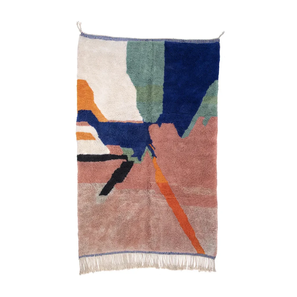 This abstract woven wall tapestry, reminiscent of a hand-knotted rug, boasts geometric shapes in blue, green, orange, pink, and beige. It features a fringe at the bottom and hanging loops at the top.