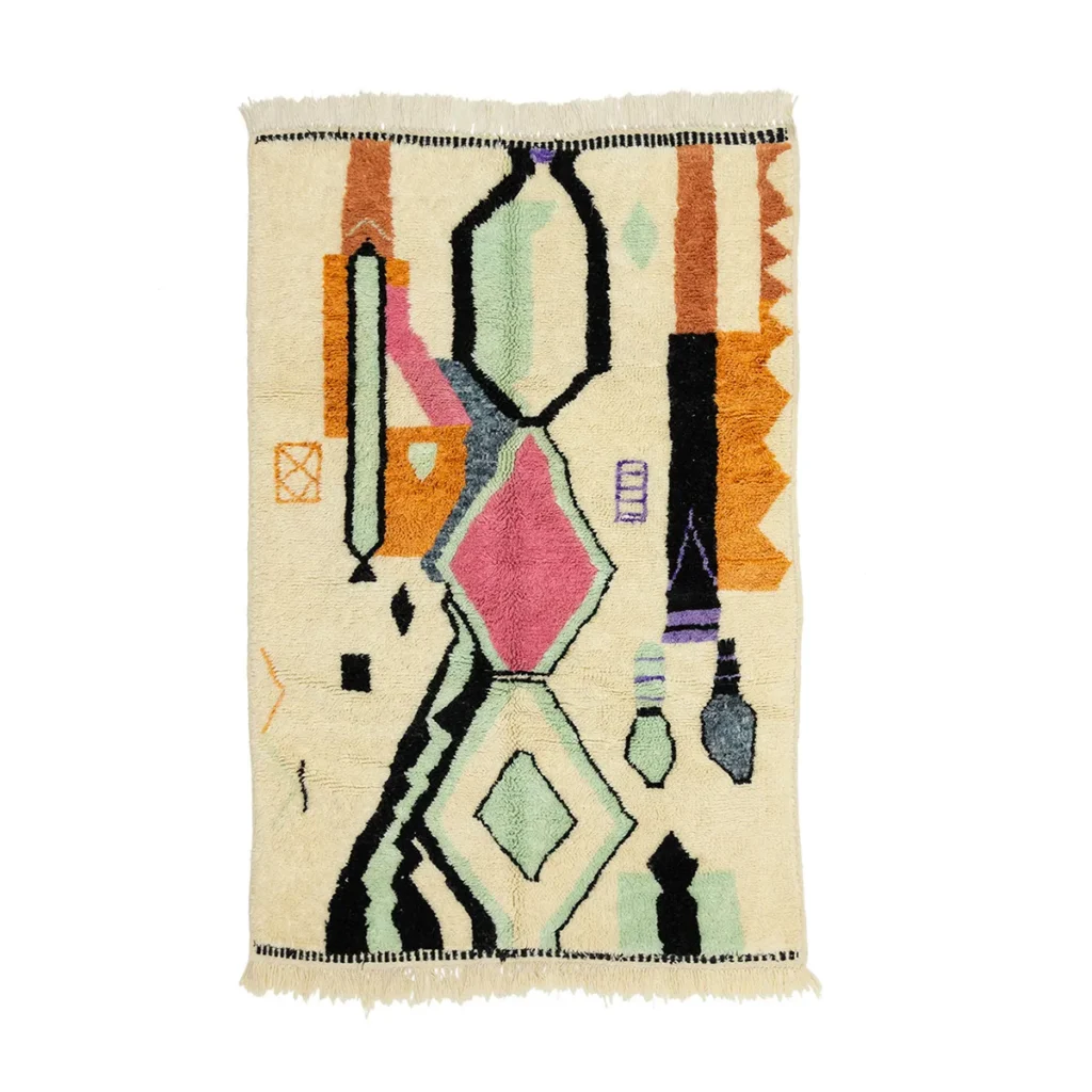 This hand-knotted rug features a colorful geometric pattern with shapes in black, green, pink, orange, and mustard on a beige background. Its intricate design adds an authentic Moroccan touch to any space.