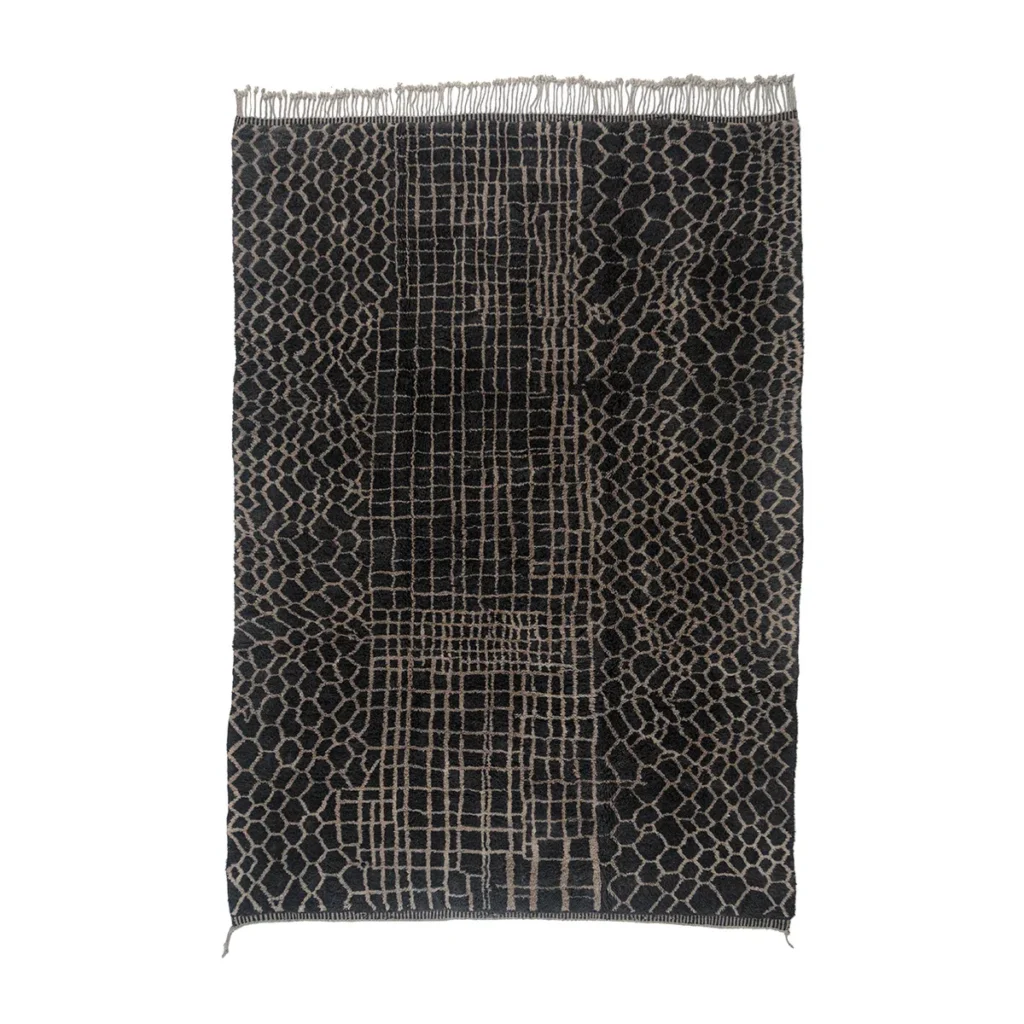 This luxury rug is a rectangular black and gray masterpiece with a woven grid and honeycomb pattern, enhanced by fringe on the shorter sides.