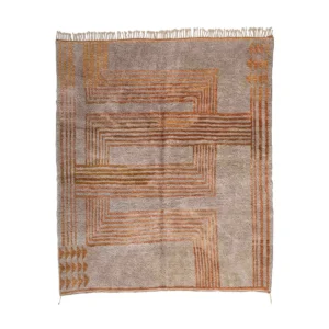 This luxury rug boasts a geometric pattern of intersecting orange lines on a light brown background, enhanced by fringes along the top and bottom edges.