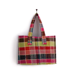 Multicolored plaid tote bag with two handles, hanging on a wall hook.