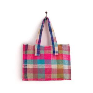 A multi-colored checkered fabric tote bag with two handles, hanging on a wall hook.