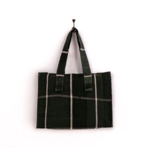 A black and gray plaid tote bag hanging on a single hook against a plain white background.