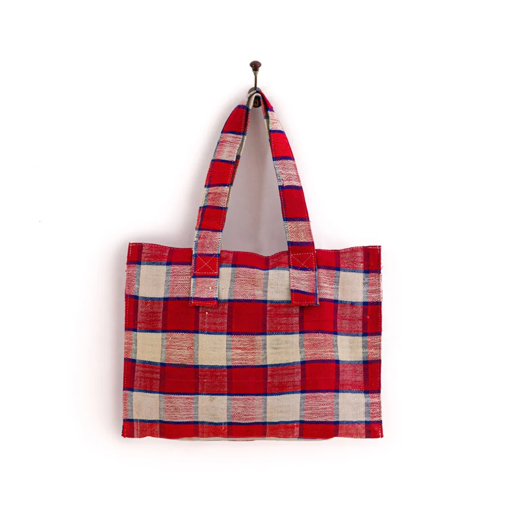 Red and white checkered tote bag hanging on a hook against a white background.