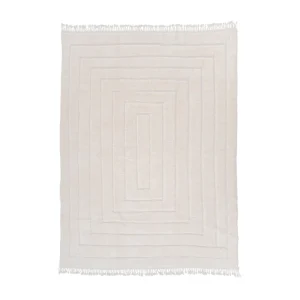 A luxurious, cream-colored rug with a raised geometric pattern and fringed edges on all sides, this hand-knotted masterpiece adds sophistication to any room.