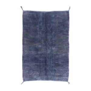 A luxurious, hand-knotted rectangular dark blue rug features light blue abstract line patterns running vertically down the center.