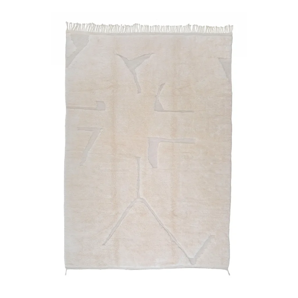 This luxurious, cream-colored rug features abstract, subtle geometric patterns and fringed edges. As a piece of handmade home decor, its perfect for adding elegance to any space.