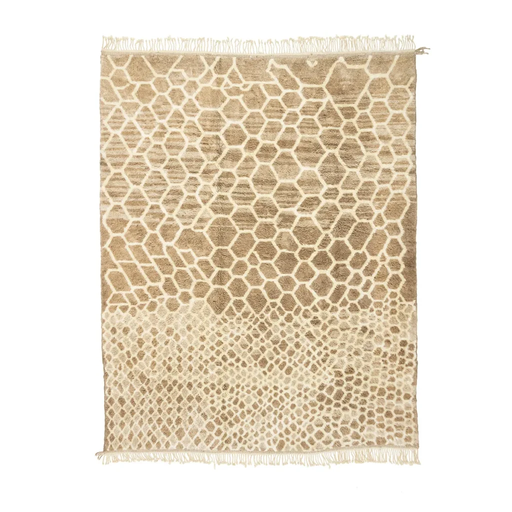 This hand-knotted, beige and brown rug features a geometric honeycomb pattern, reminiscent of authentic Moroccan rugs. Its artisanal design is complemented by fringe on the shorter sides, adding a touch of elegance to any room.