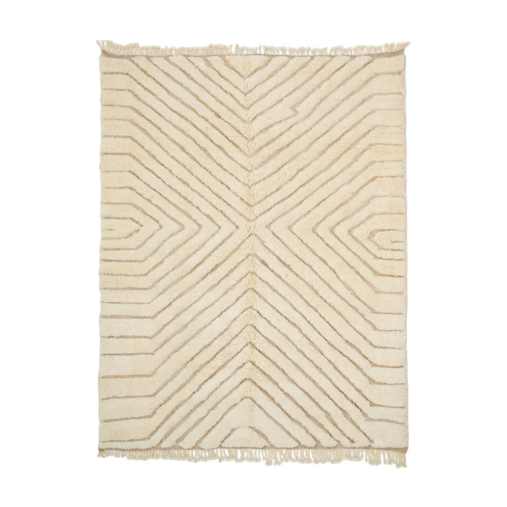 An artisanal rug, this rectangular beige piece showcases a hand-knotted geometric pattern with intersecting lines and fringe on the short edges. It exudes the charm of authentic Moroccan rugs in every detail.