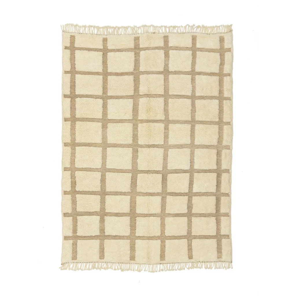 An authentic Moroccan artisanal rug in beige and cream features a checkered grid pattern with fringed edges.