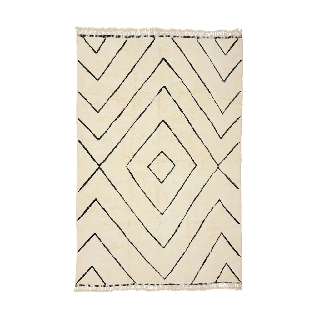 This luxurious beige rug, featuring a geometric black diamond pattern and fringed edges, is hand-knotted to perfection.