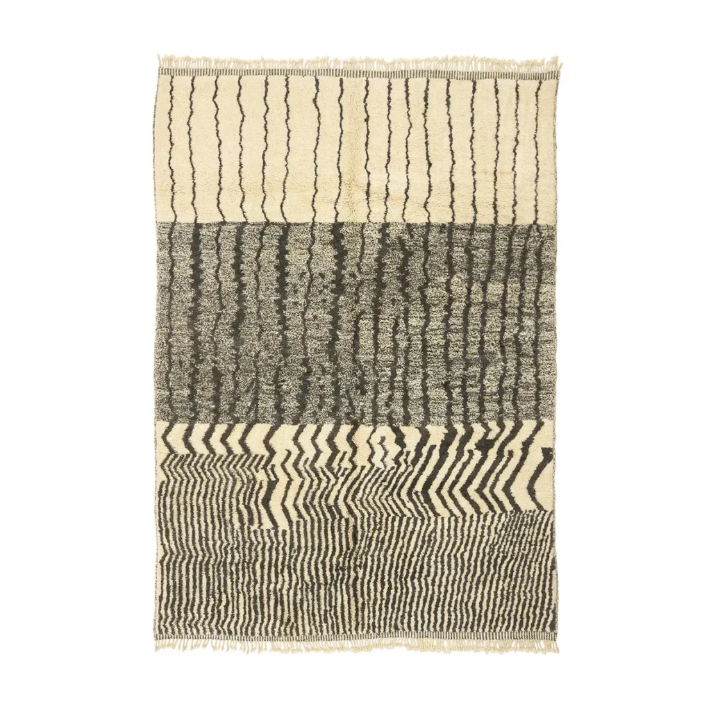 An artisanal rug with three sections displays abstract black and white patterns, including wavy, zigzag, and ripple designs.