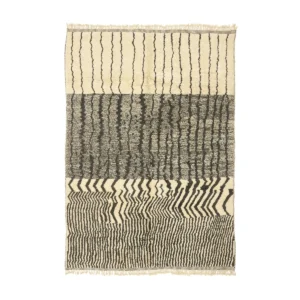 An artisanal rug with three sections displays abstract black and white patterns, including wavy, zigzag, and ripple designs.