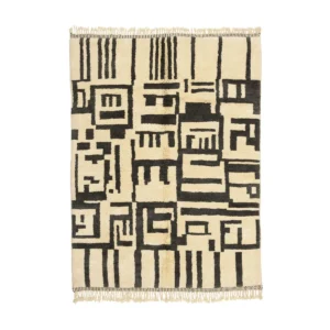 This handmade home decor piece is a cream and black rectangular rug showcasing an abstract geometric pattern with bold lines and shapes, complemented by fringed edges.