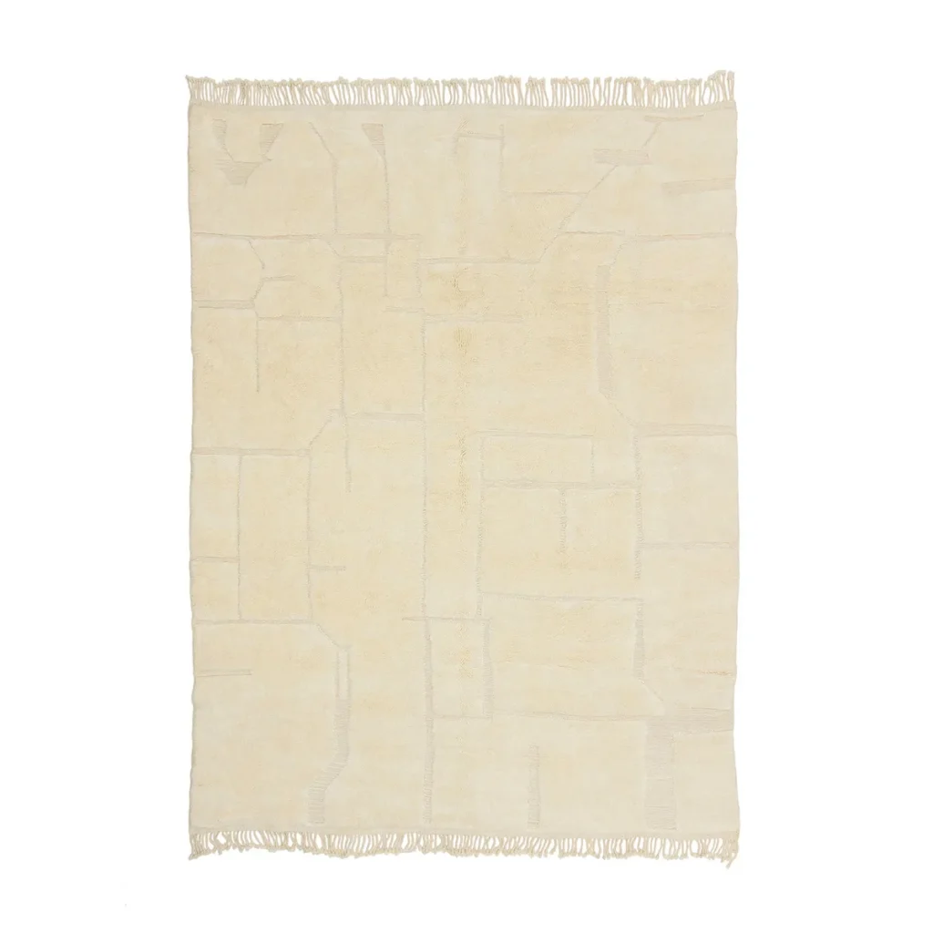 This authentic Moroccan rug features a rectangular beige design with fringed edges and a subtle geometric pattern, exuding artisanal craftsmanship.