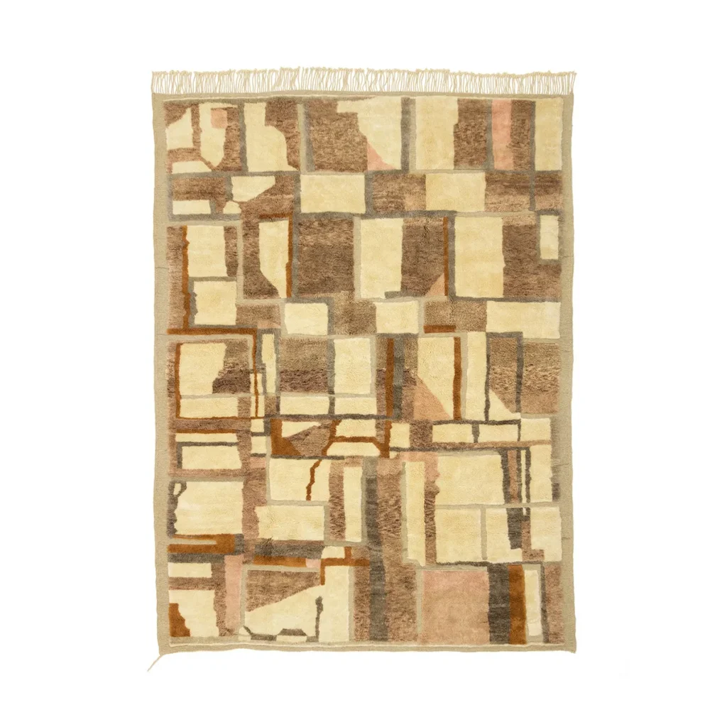 This hand-knotted, rectangular abstract geometric rug showcases a patchwork pattern of brown, beige, and cream squares and rectangles. It features a fringed edge at the top, adding a touch of sophistication to any room.