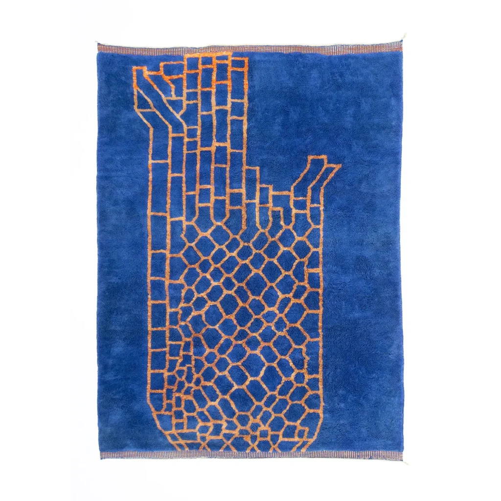 This blue rectangular artisanal rug features an orange geometric pattern reminiscent of a tall, abstract structure. The edges are elegantly lined with thin, multicolored stripes, showcasing the craftsmanship of authentic Moroccan rugs.