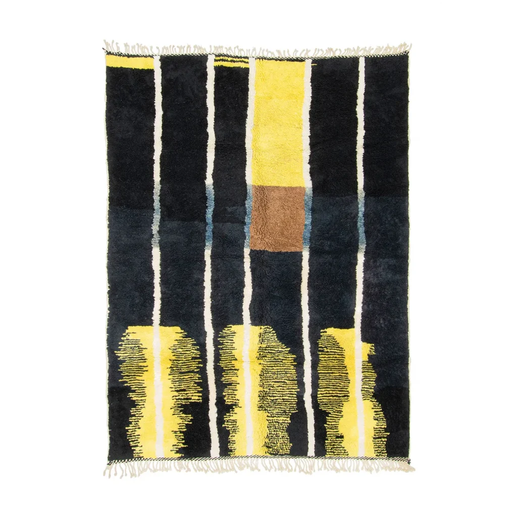 Discover an authentic Moroccan rug featuring vertical stripes in dark blue, yellow, and a central brown square. The stripes offer varied thickness and texture, some with a woven pattern, all hand-knotted to perfection. This artisanal piece is finished with elegant white fringes at the edges.