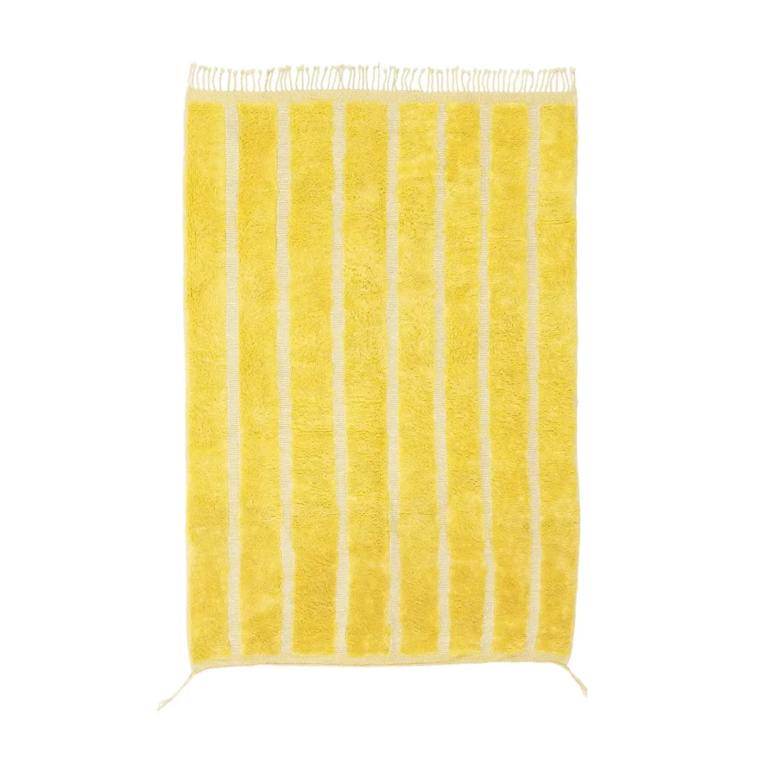 A luxurious yellow rectangular rug featuring vertical cream stripes and hand-knotted fringed edges, perfect for adding a touch of elegance to any space.