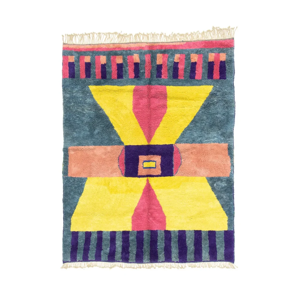 This authentic Moroccan rug showcases vibrant geometric patterns in yellow, pink, blue, and purple, with captivating stripes and shapes. The hand-knotted design highlights its artisanal craftsmanship, while fringed edges gracefully accent the top and bottom.