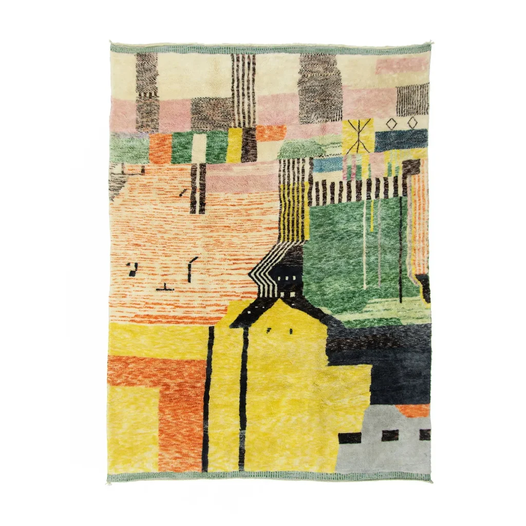 An artisanal rug featuring a colorful abstract design with geometric shapes and patterns in yellow, green, pink, and black tones. Its hand-knotted construction creates an authentic patchwork-like appearance reminiscent of Moroccan craftsmanship.