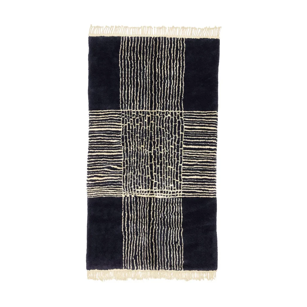 This luxurious, hand-knotted rug features a black rectangular design adorned with intricate cream vertical and horizontal line patterns, complemented by fringed edges.