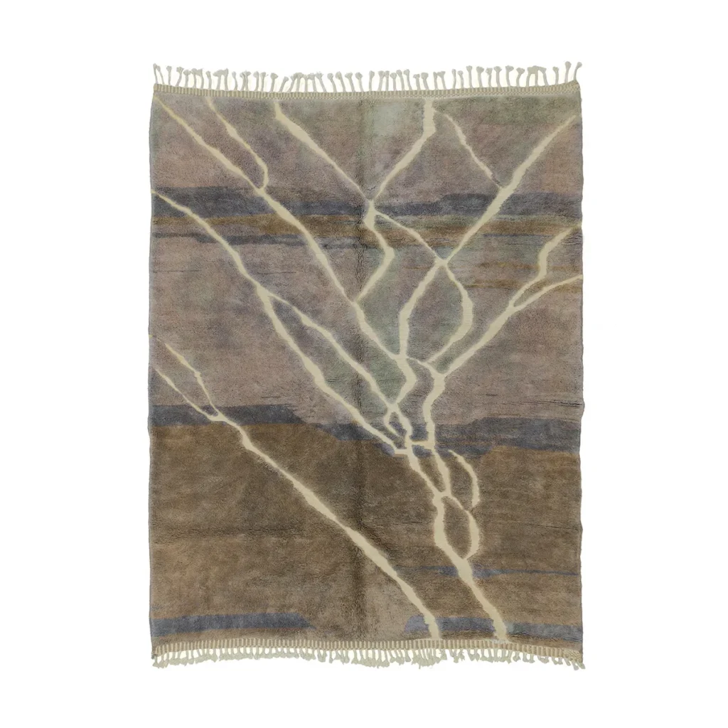 An artisanal rug with fringe edges, this rectangular piece is hand-knotted and textured. It showcases an abstract design with overlapping beige, brown, and blue-gray lines, making it a stylish addition to any room.