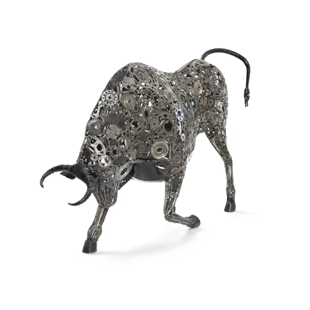 A recycled bull sculpture crafted from interlocking metal gears and parts, poised as if charging, with a raised tail and lowered head, exemplifying stunning metalwork artistry.