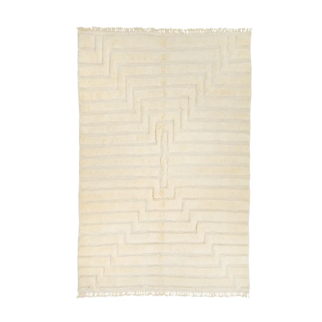A beige rug with a textured zigzag pattern and fringed edges.