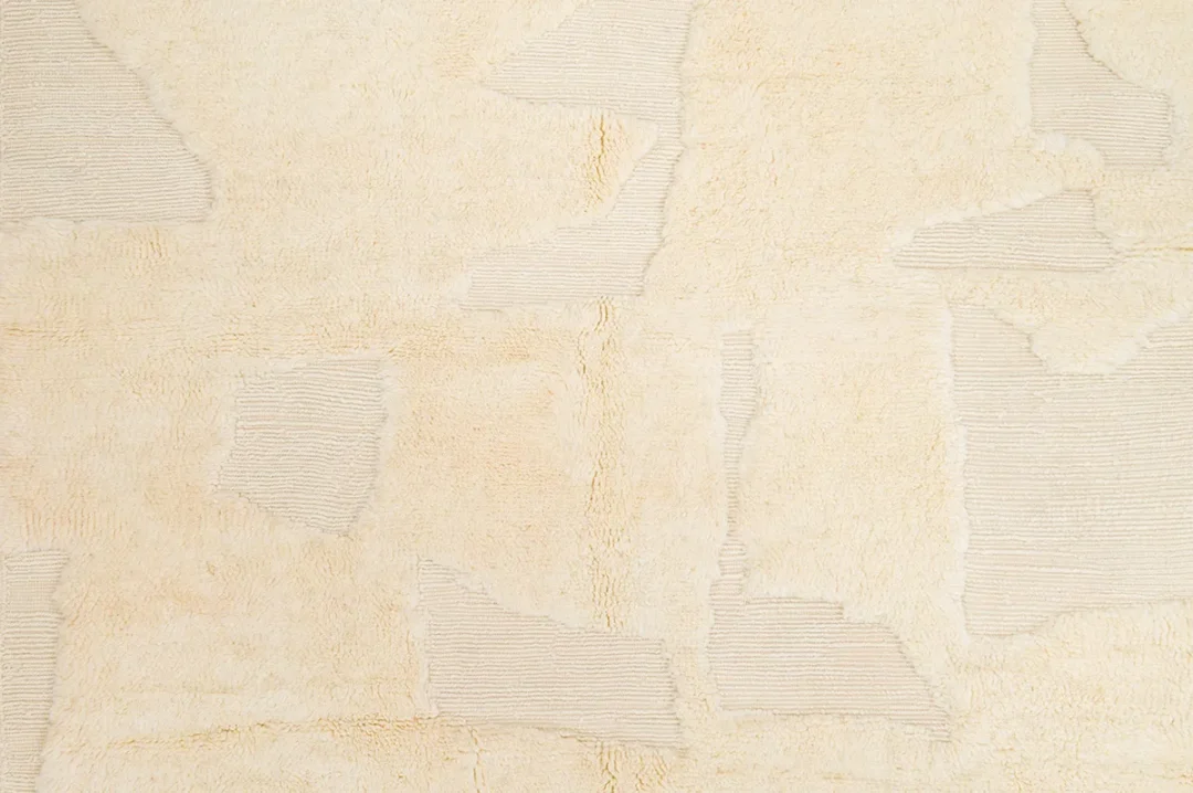 Close-up of a beige textured surface with abstract geometric patterns featuring varying shades and lines.