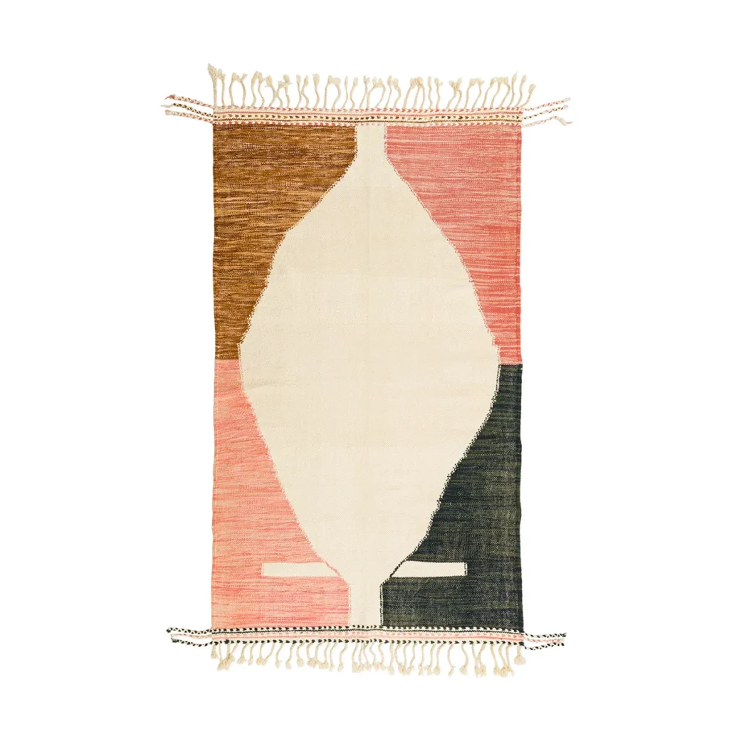 A woven rug with abstract geometric shapes in brown, pink, white, and dark green, featuring fringed edges on the top and bottom.