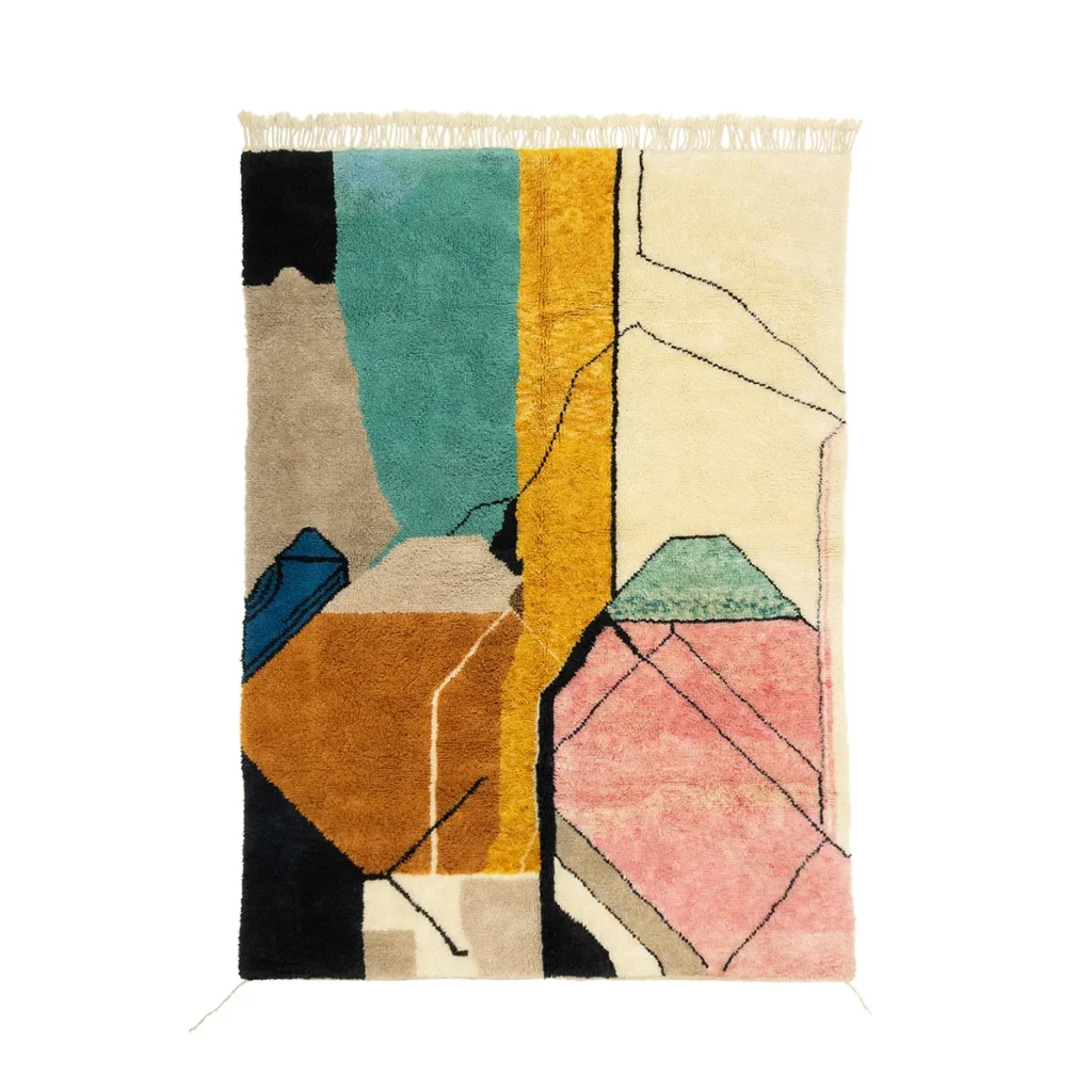 A colorful abstract rug with geometric shapes in shades of blue, pink, yellow, and black, featuring fringe at the top.