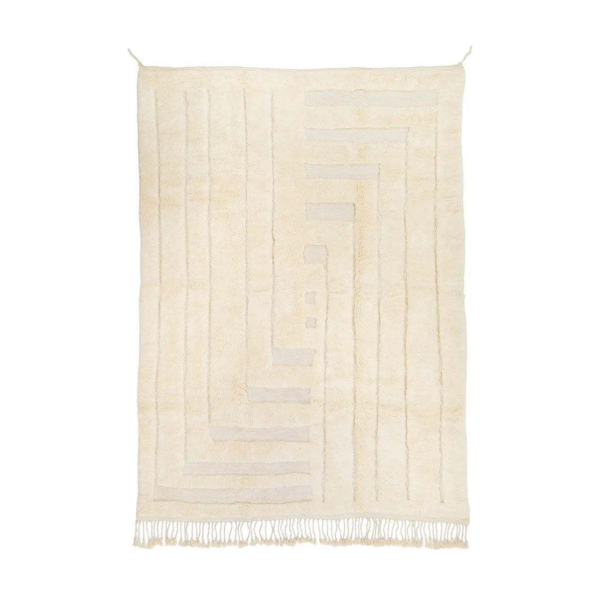 A beige geometric-patterned rug with vertical lines and shapes. It features fringe at the bottom edges, hanging against a plain white background.