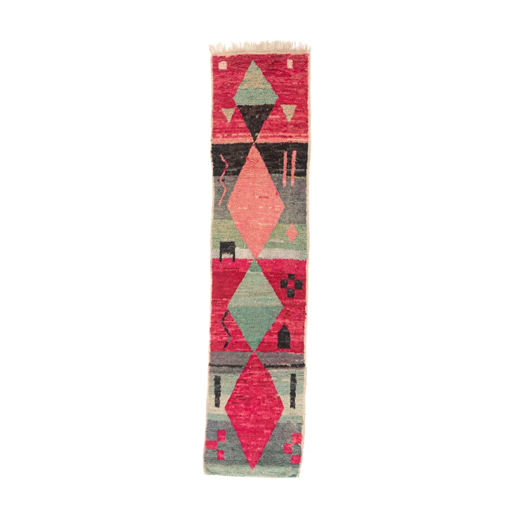 A long, narrow rug with geometric patterns in shades of red, green, blue, and black.