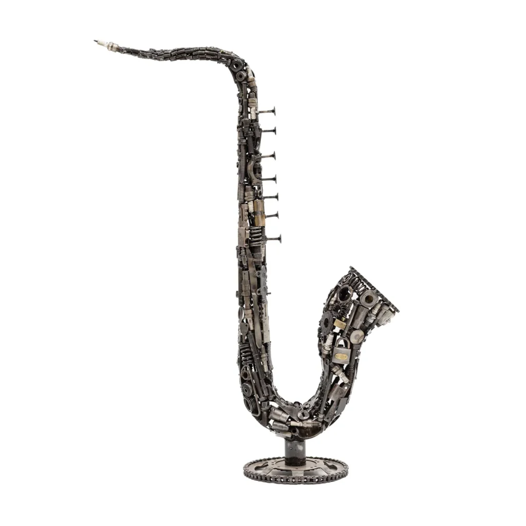 Saxophone sculpture made from metallic parts and gears on a circular base, resembling a traditional saxophone shape.