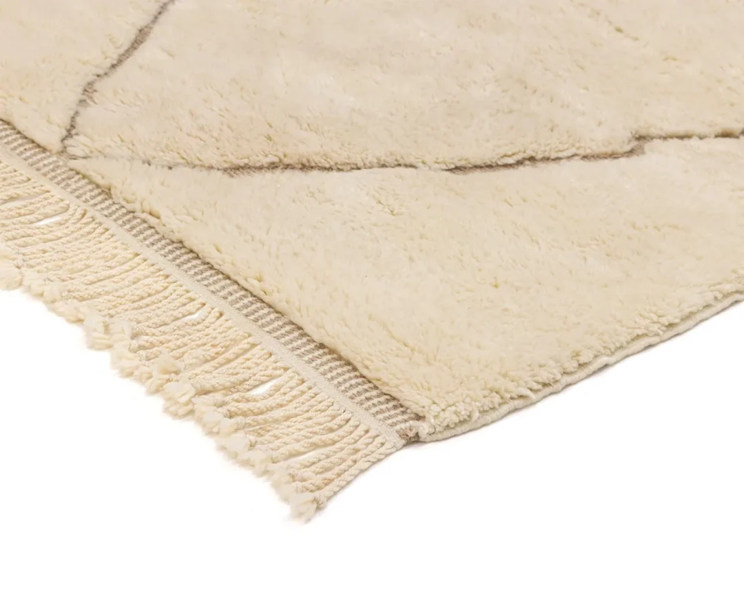 A beige, fluffy rug with a simple line pattern and fringed edges.