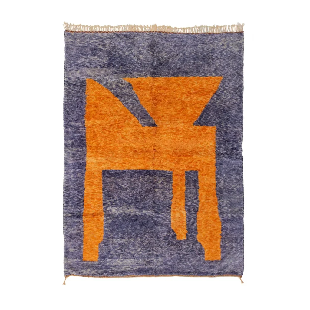 A rectangular area rug with a blue background and an abstract orange geometric design in the center.