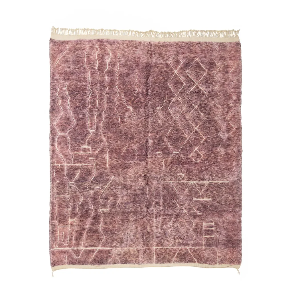 A textured, mauve area rug with abstract geometric patterns and fringed edges.