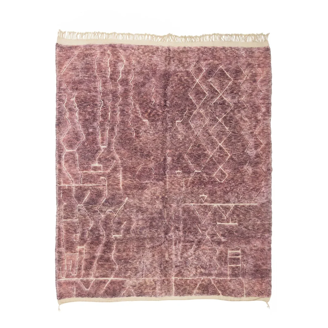 A textured, mauve area rug with abstract geometric patterns and fringed edges.