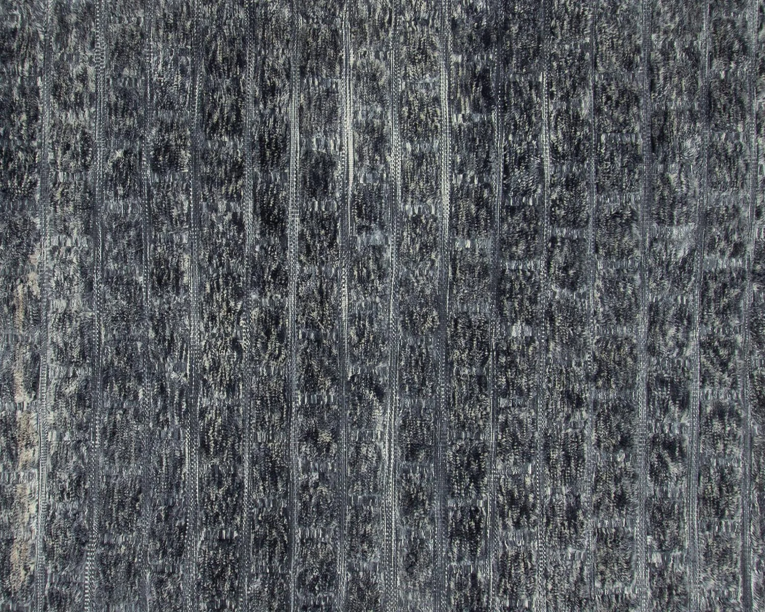 Close-up of a textured dark gray carpet with a subtle vertical pattern.