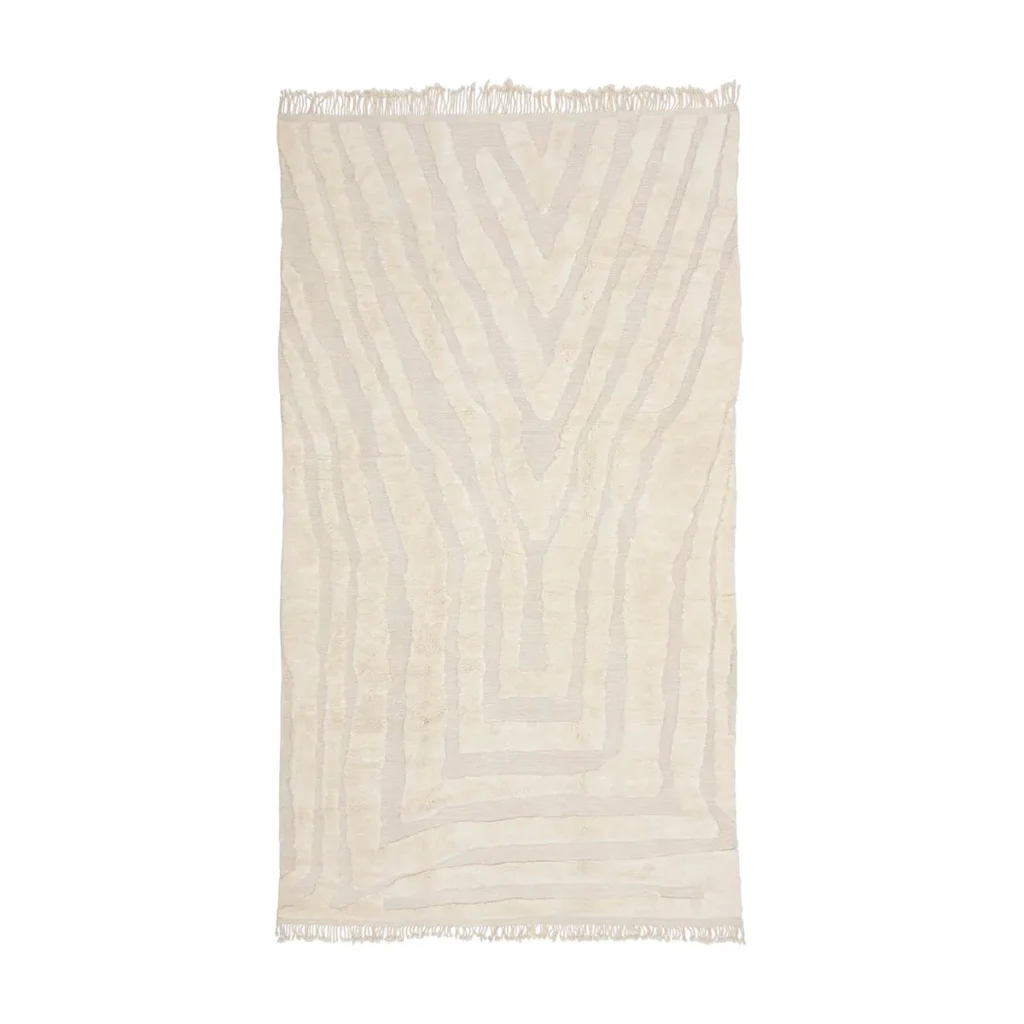 Rectangular cream-colored rug with subtle geometric line patterns and fringe on both shorter edges, displayed on a white background.