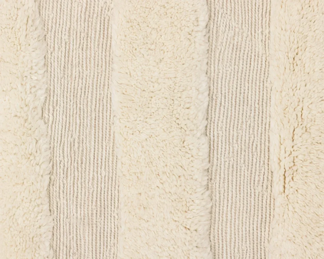 Close-up of a beige striped fabric with alternating bands of fluffy and ribbed textures.