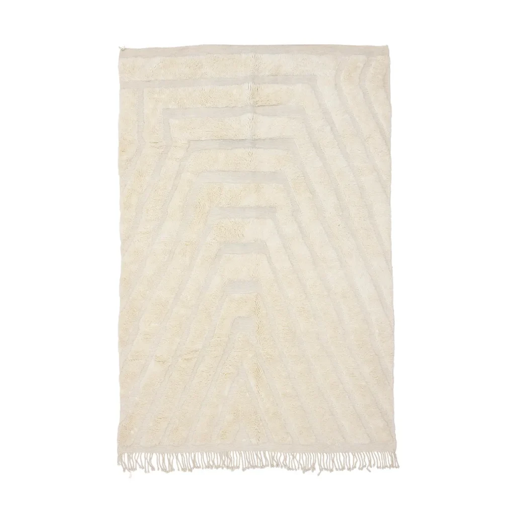 Rectangular cream-colored rug with subtle geometric patterns and fringed edges at the bottom.