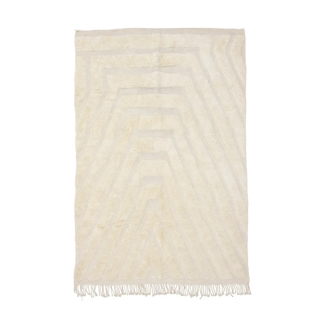 Rectangular cream-colored rug with subtle geometric patterns and fringed edges at the bottom.